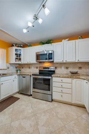 a kitchen with stainless steel appliances granite countertop a stove and cabinets