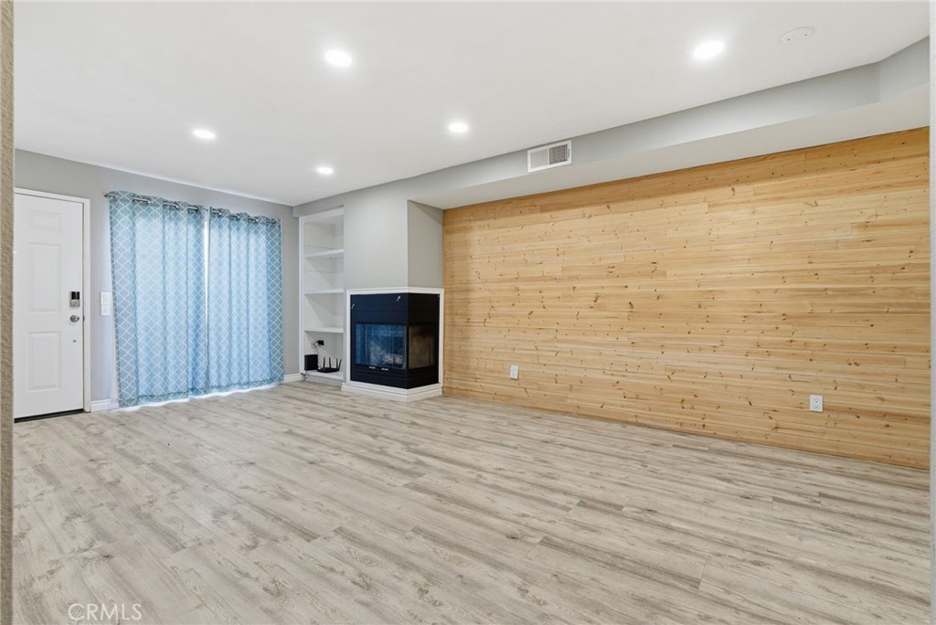 8594 Shramsburg Drive Rancho Cucamonga, CA 91730 - Photo 11 of 43 a view of empty room with wooden floor and fireplace