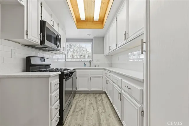 a kitchen with stainless steel appliances granite countertop a sink and a stove
