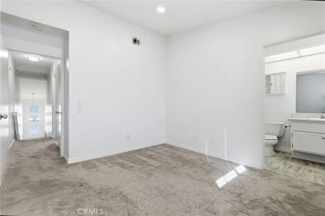 a view of a room with an empty space and a bathroom