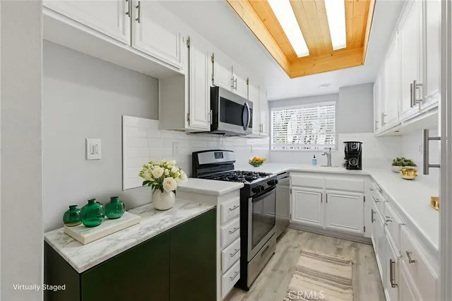 a kitchen with stainless steel appliances a white cabinets stove and a refrigerator