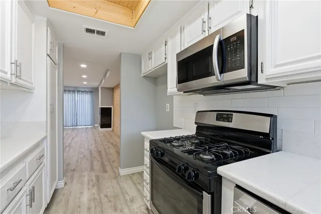 a kitchen with stainless steel appliances granite countertop a stove and a microwave