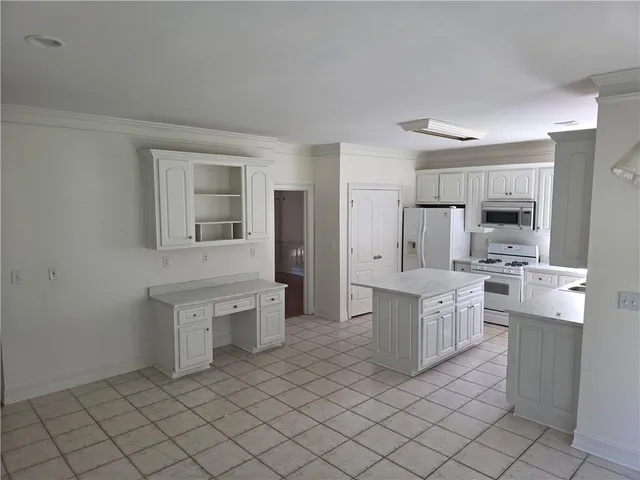 a large white kitchen with cabinets and stainless steel appliances