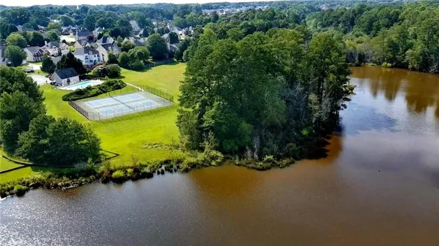 an aerial view of a house with a yard and lake view