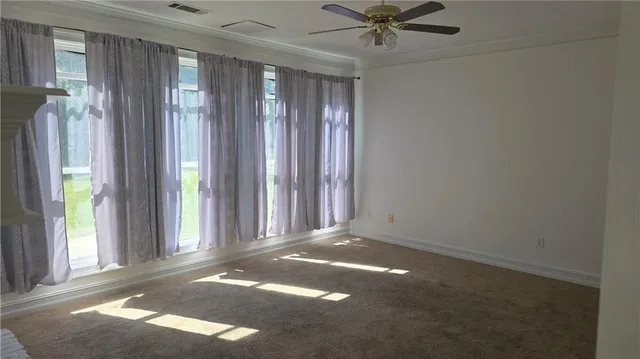 a view of a livingroom with a ceiling fan and window
