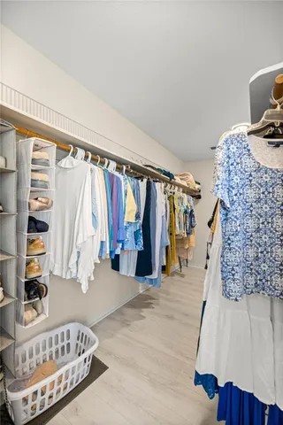 a view of walk in closet with clothes and shoes