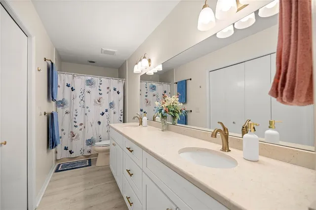 a bathroom with a double vanity sink mirror and shower