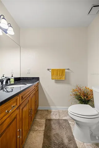 a spacious bathroom with a granite countertop toilet and a sink