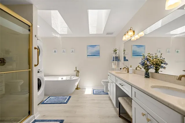a spacious bathroom with a bathtub sink mirror and toilet