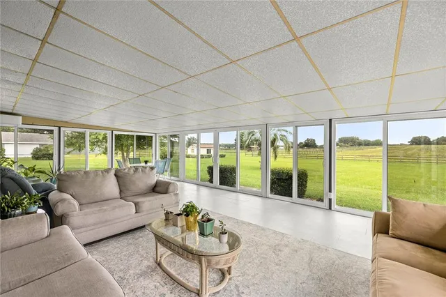 a living room with furniture and floor to ceiling windows