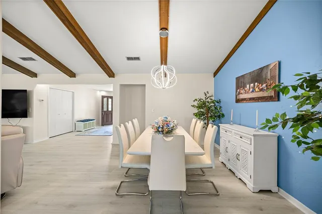 a dining room with furniture and a floor to ceiling window