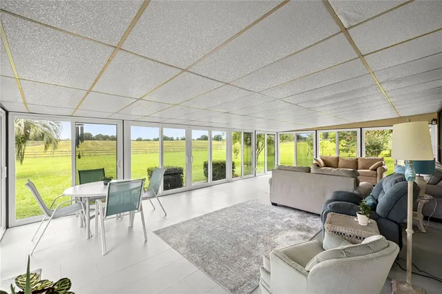 a living room with furniture and floor to ceiling windows