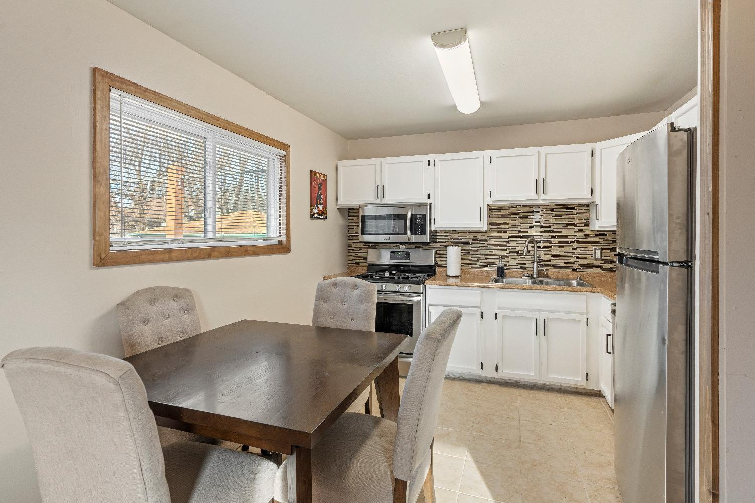 1412 North Elmer Street Griffith, IN 46319 - Photo 5 of 23 a kitchen with stainless steel appliances granite countertop a refrigerator a stove a sink dishwasher and white cabinets with wooden floor