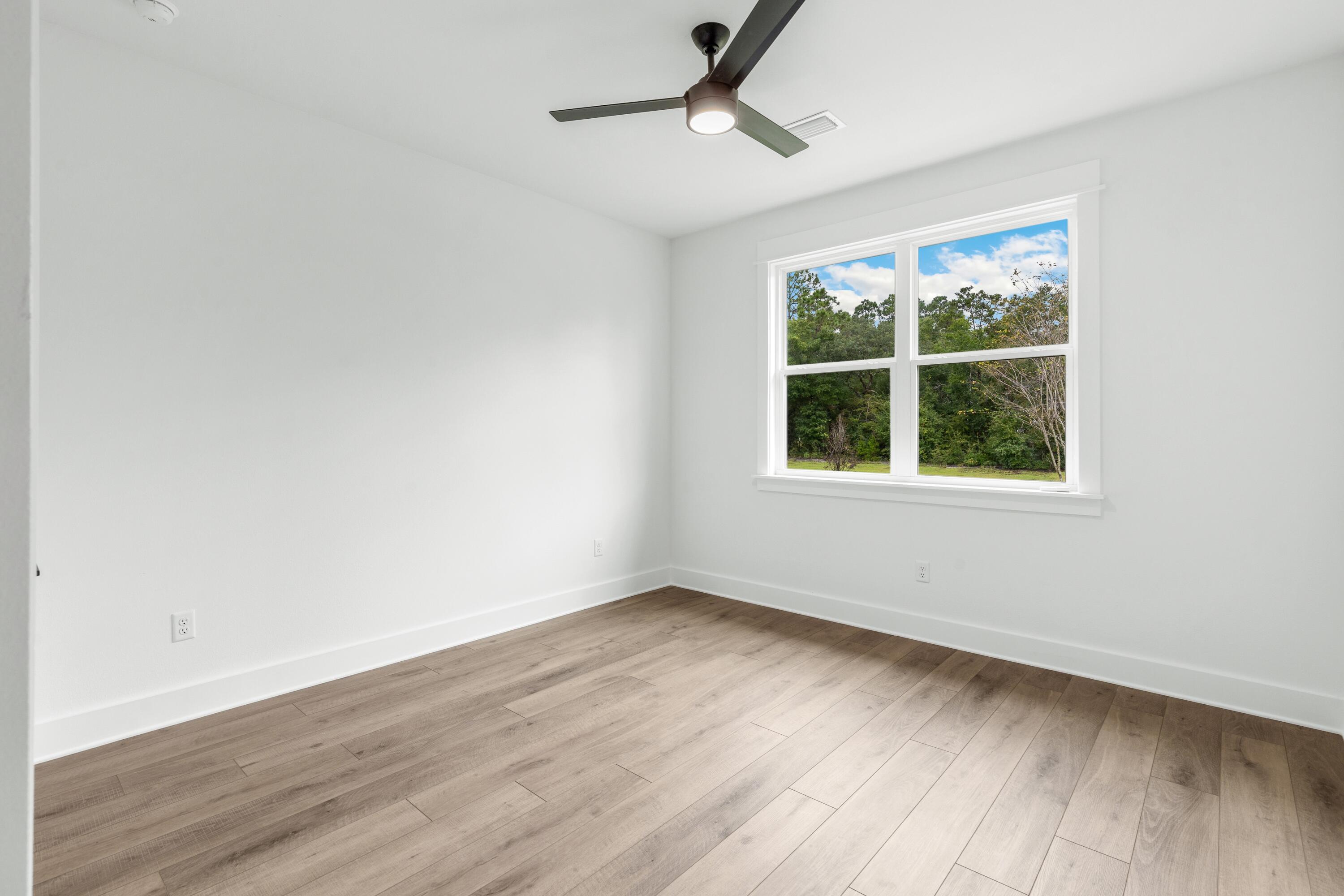 80 Clarke Hl Road Freeport, FL 32439 - Photo 14 of 33 an empty room with wooden floor and windows