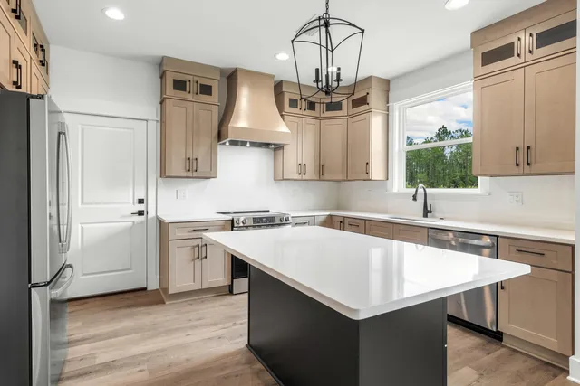 a kitchen with a stove a sink dishwasher and a refrigerator