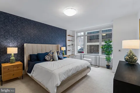 a bedroom with a bed and a dresser next to a window