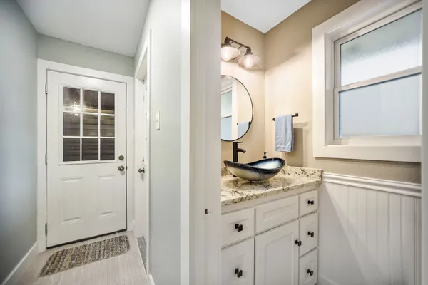 a bathroom with a granite countertop sink and a mirror