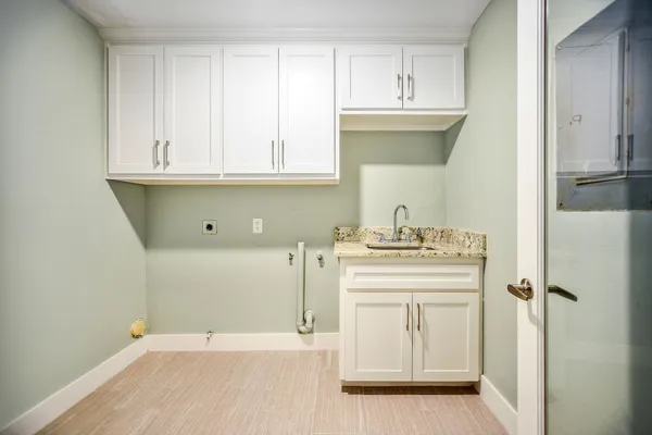 a room with a sink cabinets and a window