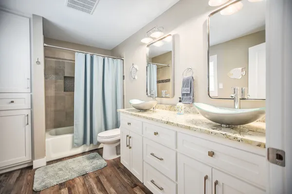 a bathroom with a granite countertop sink toilet and shower