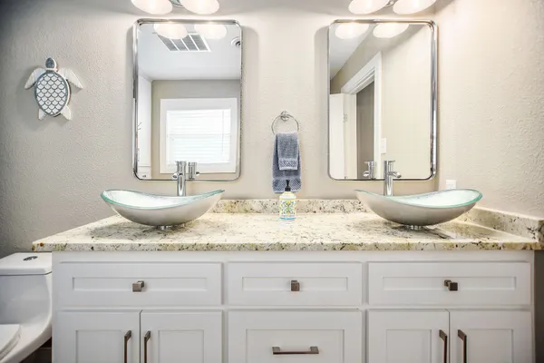 a bathroom with a granite countertop sink and a mirror