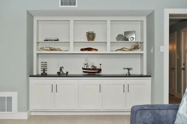 a kitchen with white cabinets and a wooden floor