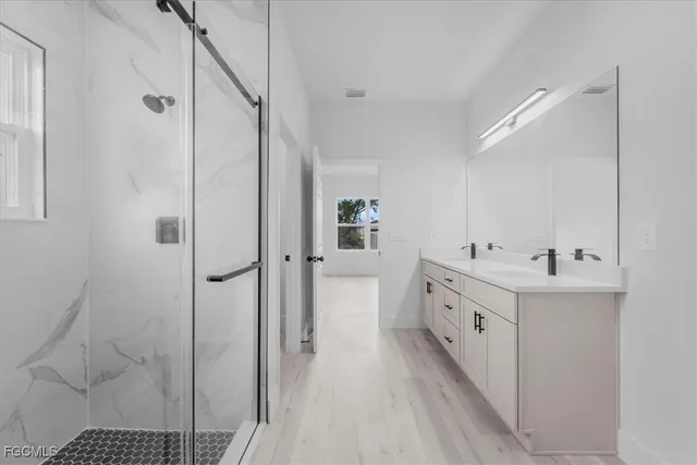 a bathroom with a double vanity sink a mirror and a shower