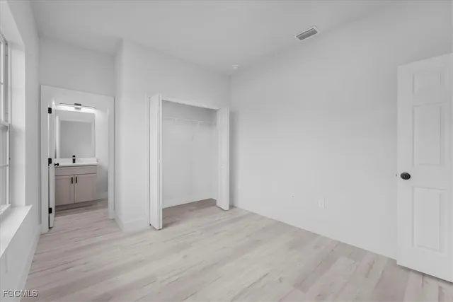 an empty room with wooden floor and a bathroom