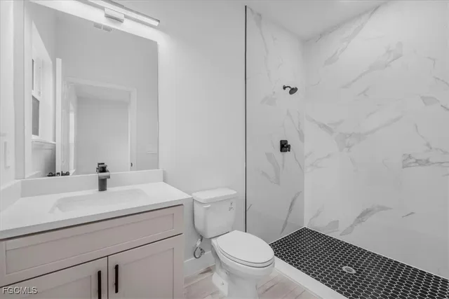 a bathroom with a sink toilet a mirror and shower