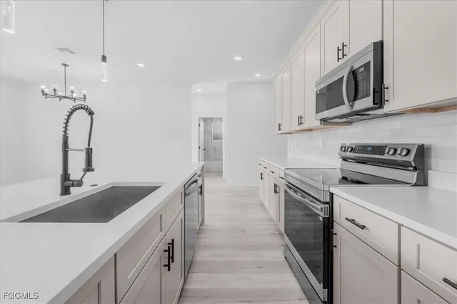 a kitchen with stainless steel appliances granite countertop a sink and a stove