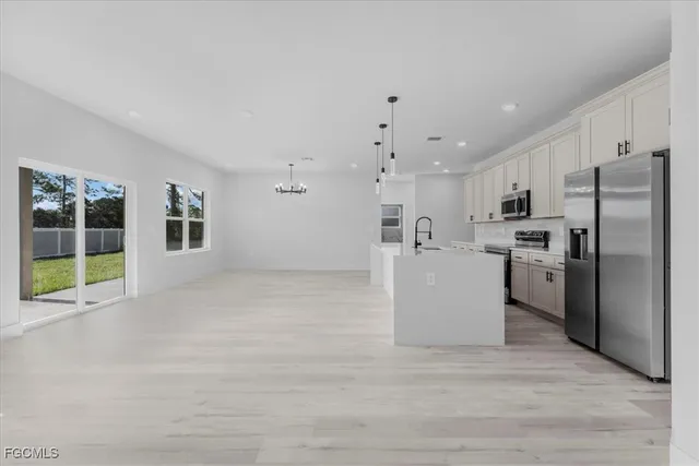 a view of a kitchen with a sink and a refrigerator