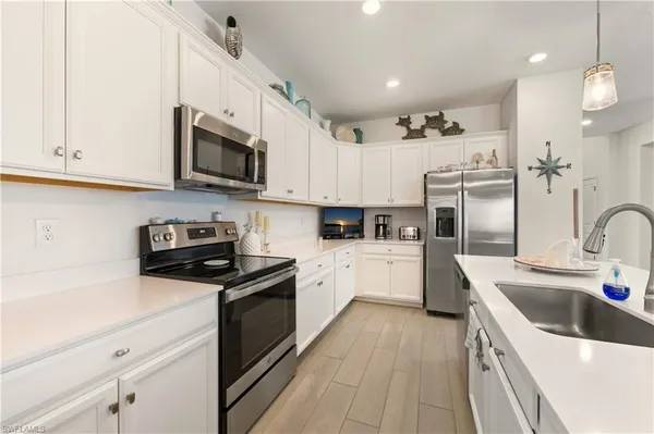 a kitchen with white cabinets and stainless steel appliances