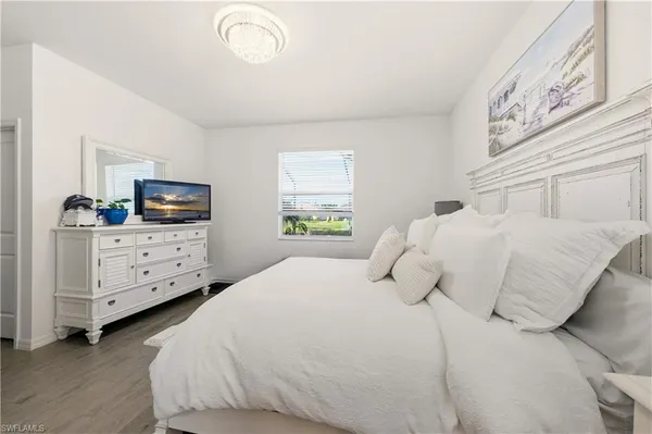 a bedroom with a bed and a tv on the dresser