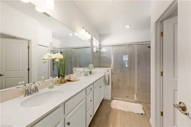 a bathroom with a double vanity sink mirror and shower