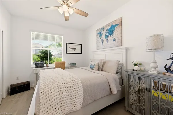 a bedroom with a bed a window and a chandelier