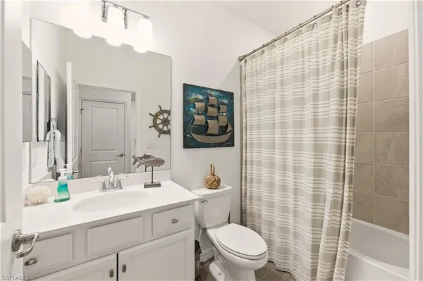 a bathroom with a sink a toilet a mirror and shower