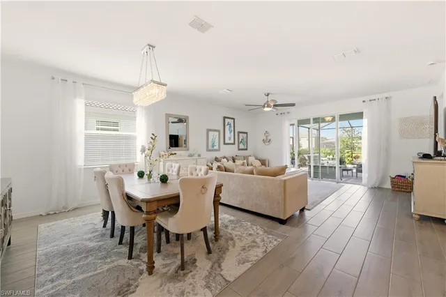 a dining room with furniture a chandelier and wooden floor