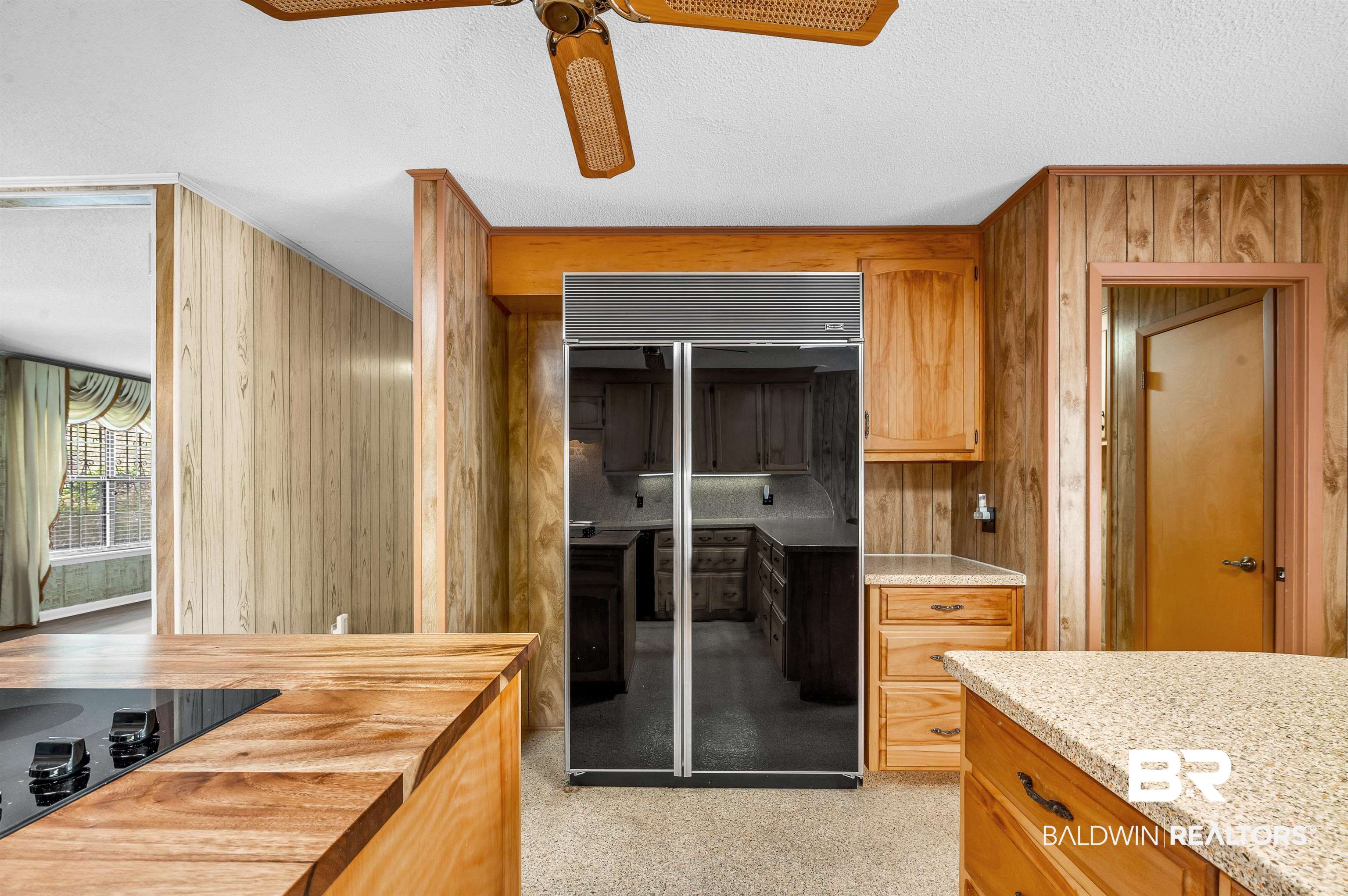 610 East Walker Avenue Foley, AL 36535 - Photo 19 of 38 Kitchen featuring black appliances, ceiling fan, wooden walls, and a textured ceiling