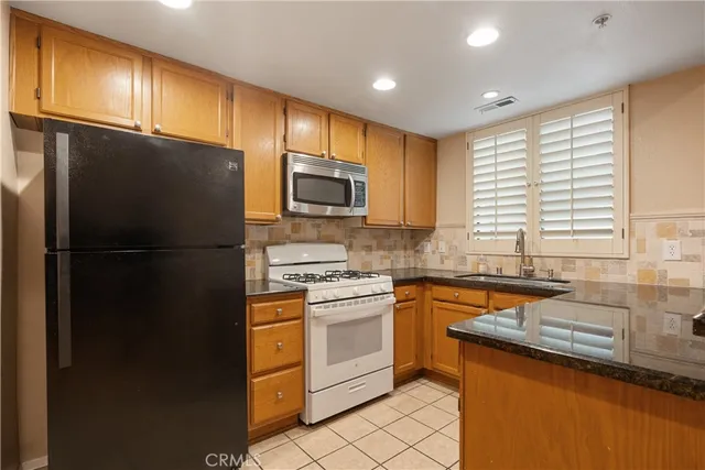 a kitchen with stainless steel appliances granite countertop a refrigerator and a stove