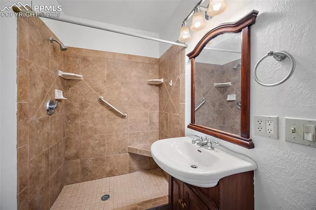 a bathroom with a sink a shower and a mirror