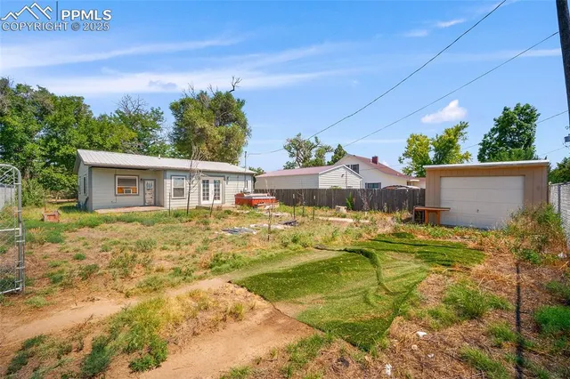 a view of house with backyard and trees