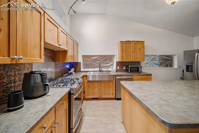 a kitchen with stainless steel appliances granite countertop a stove a sink and a microwave