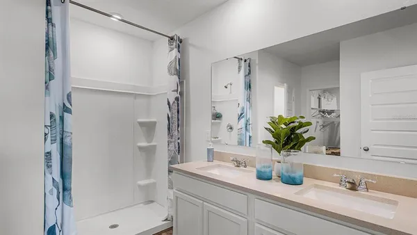 a bathroom with a granite countertop sink a toilet a mirror and shower