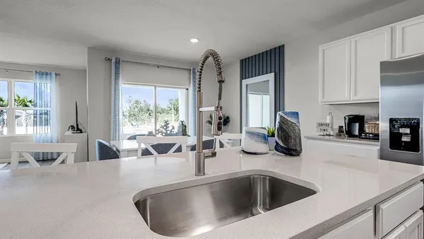 a kitchen with sink refrigerator and large window