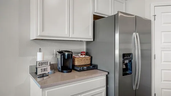 a kitchen with refrigerator and cabinets