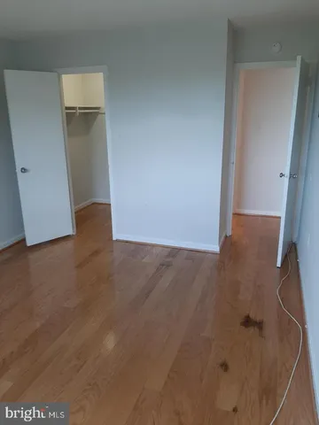 an empty room with wooden floor and sink