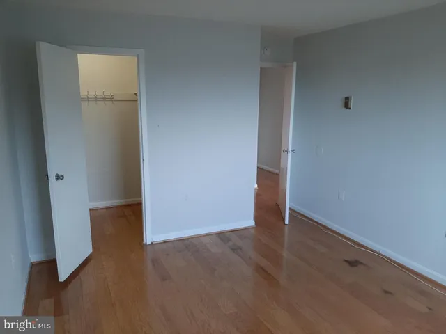 an empty room with wooden floor and closet