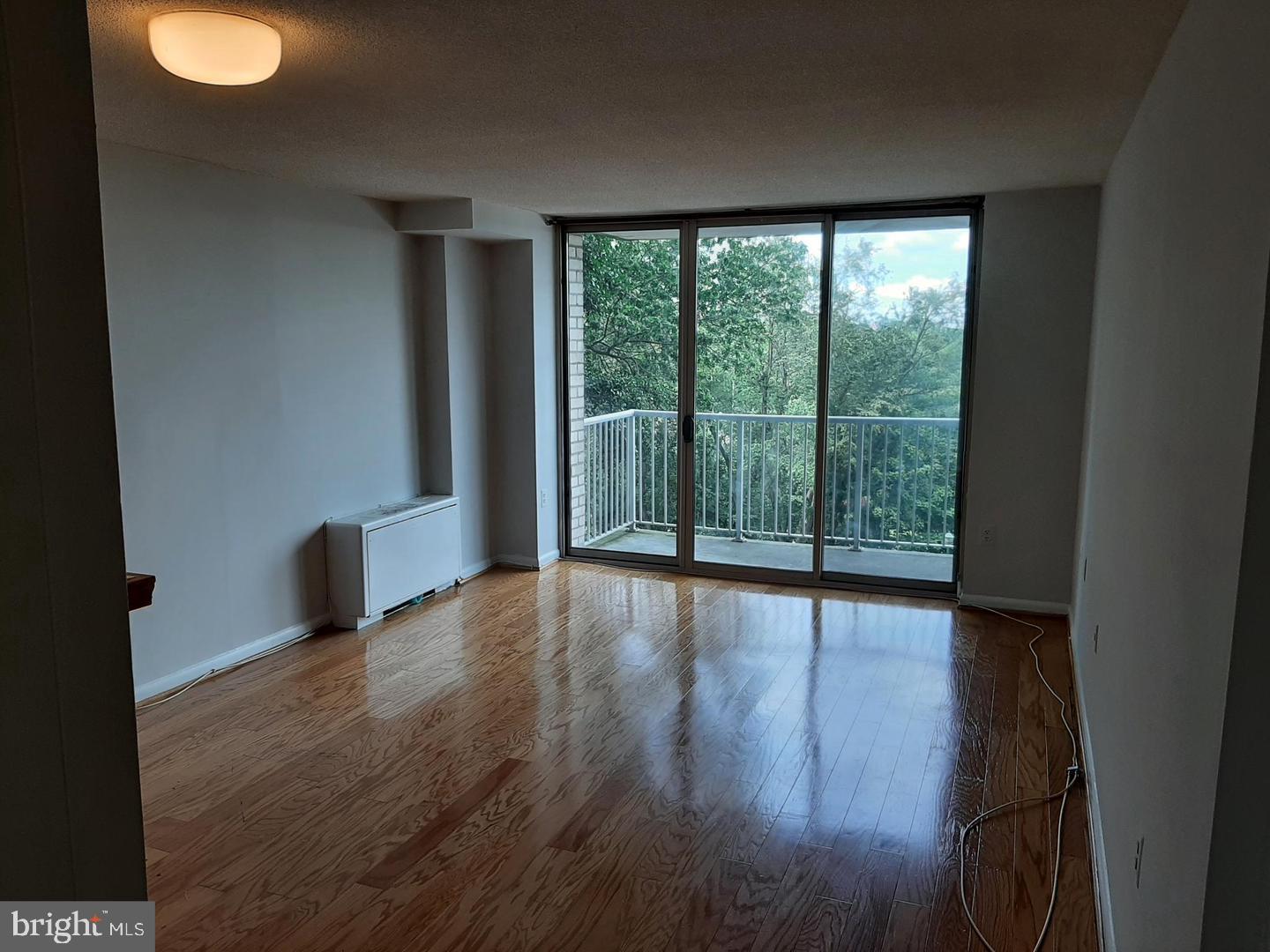 2500 North Van Dorn Street, Unit 419 Alexandria, VA 22302 - Photo 6 of 20 an empty room with wooden floor and windows