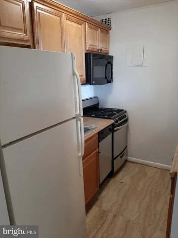 a kitchen with a refrigerator and a stove