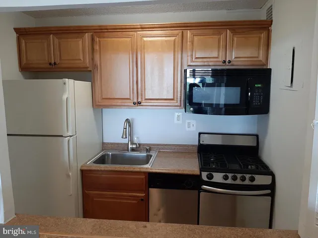 a kitchen with granite countertop a refrigerator stove and microwave