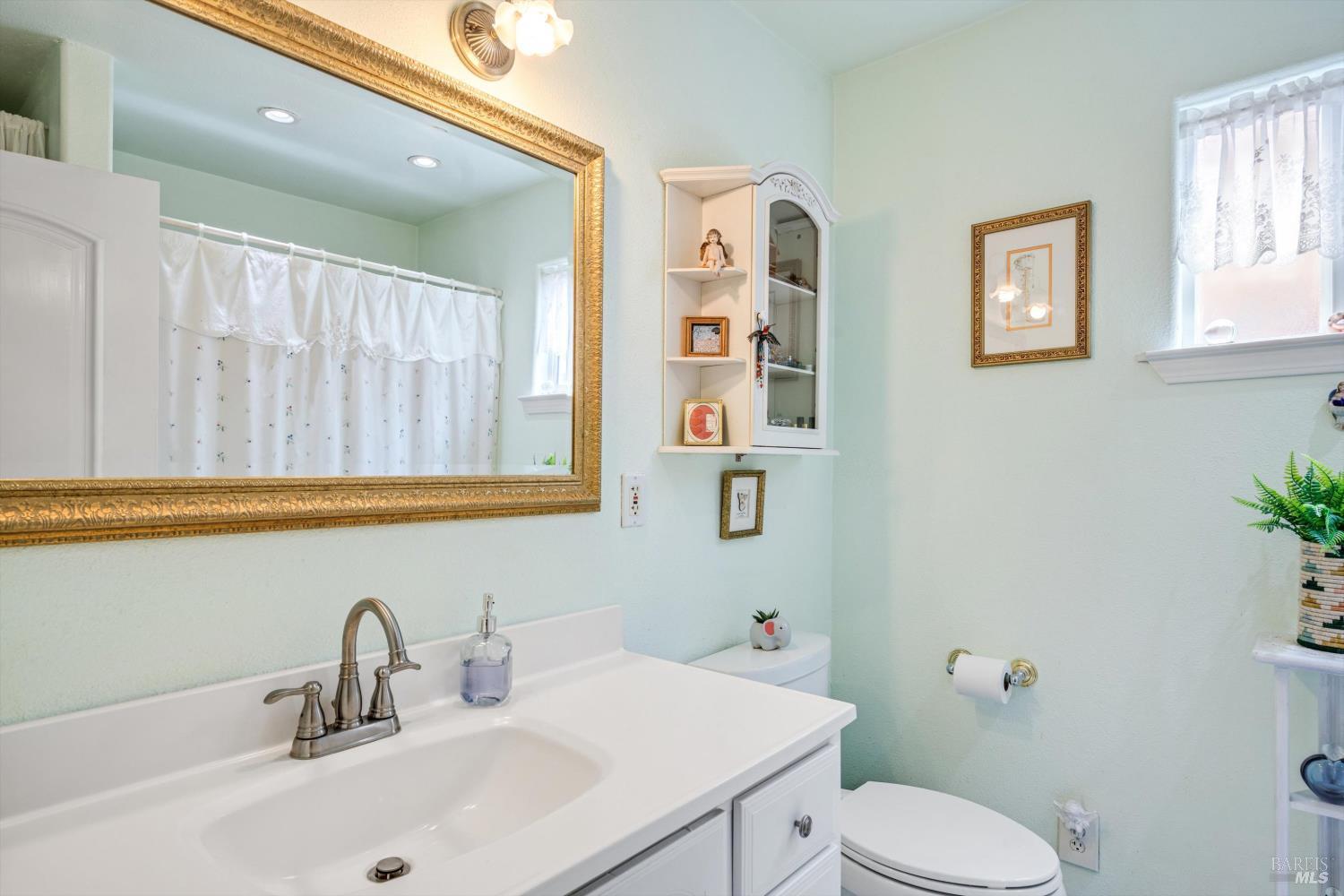 971 Eleanor Avenue Rohnert Park, CA 94928 - Photo 19 of 25 a bathroom with a sink a toilet and mirror